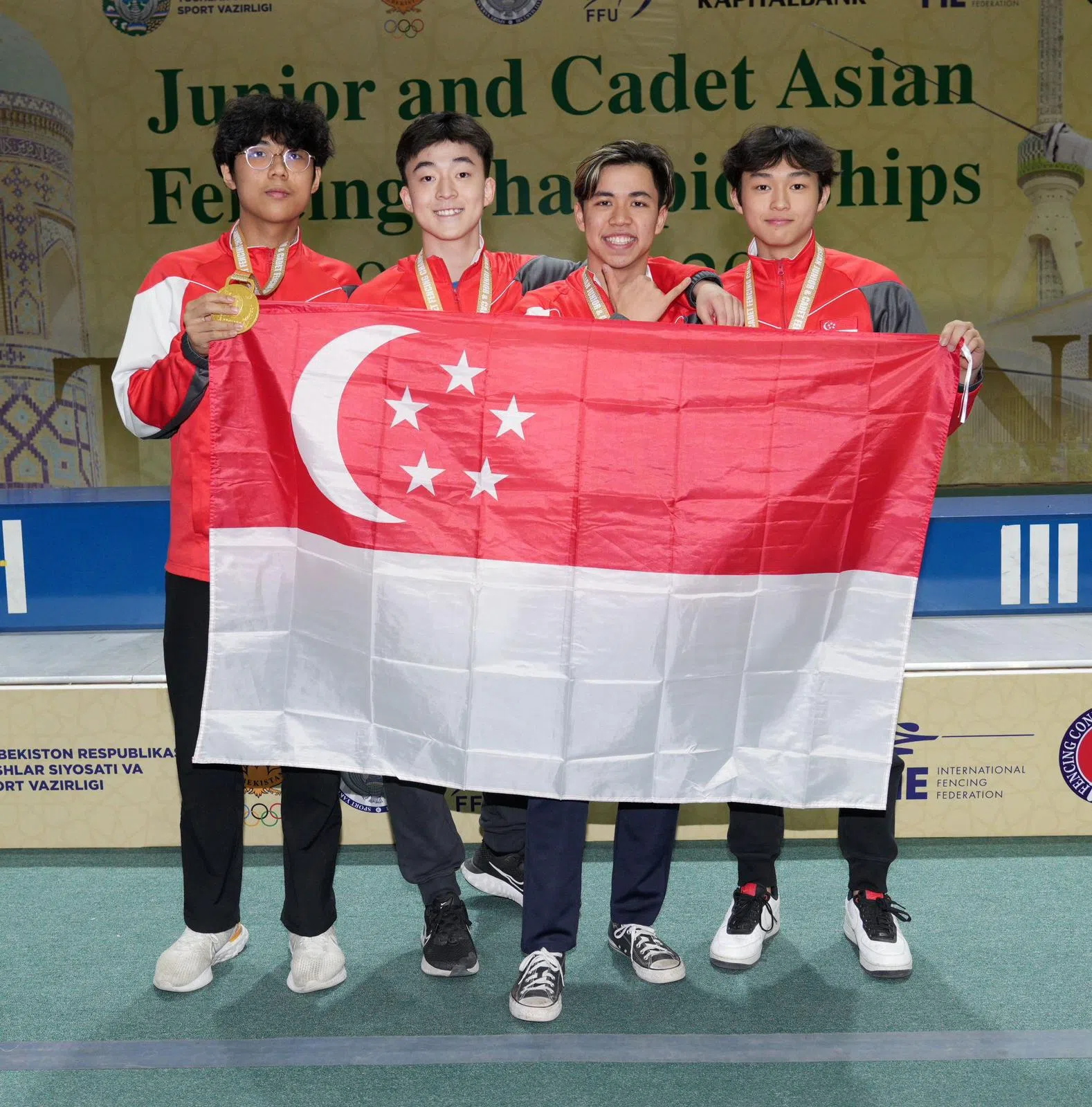 杜昀韬（左二）与队友全力以赴，为新加坡赢得亚青赛少年组花剑团体赛首枚金牌，载誉归来。（新加坡击剑总会提供）