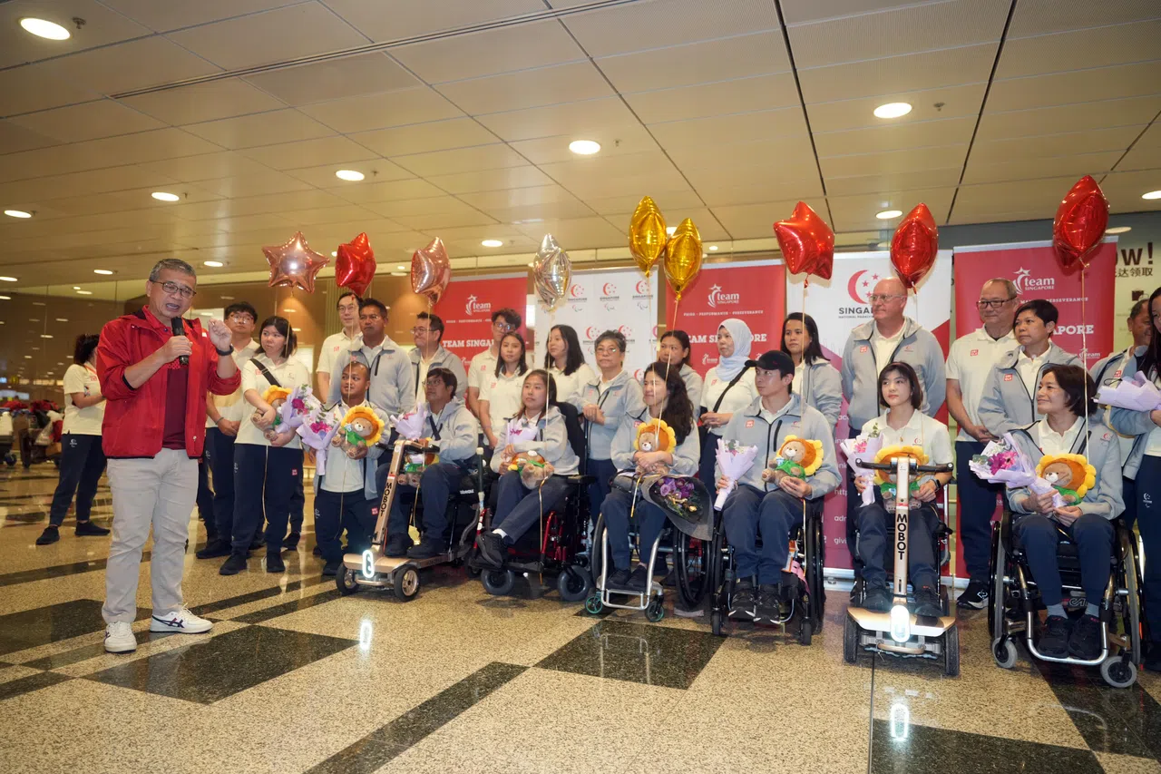 唐振辉部长（红衣）向我国健儿及到场的支持者及媒体发言，感谢选手及他们的教练和幕后团队的努力。（谢智扬摄）