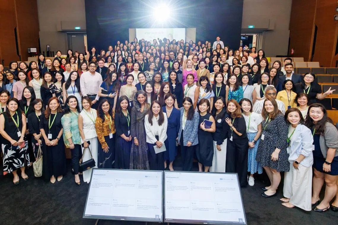 陈淑珊（前排白衣者）近期出席新加坡金融业女性协会的一场活动，与会员合影。（受访者提供）