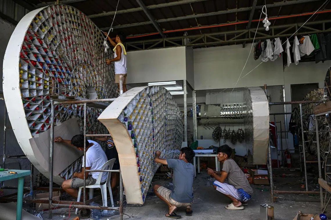 在菲律宾圣费尔南多市，灯笼制作工人忙着组装巨型灯笼，以参与今年的灯笼节。（法新社）