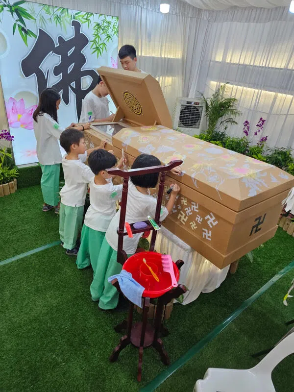 家属在纸质棺材上面留言。（受访者提供）