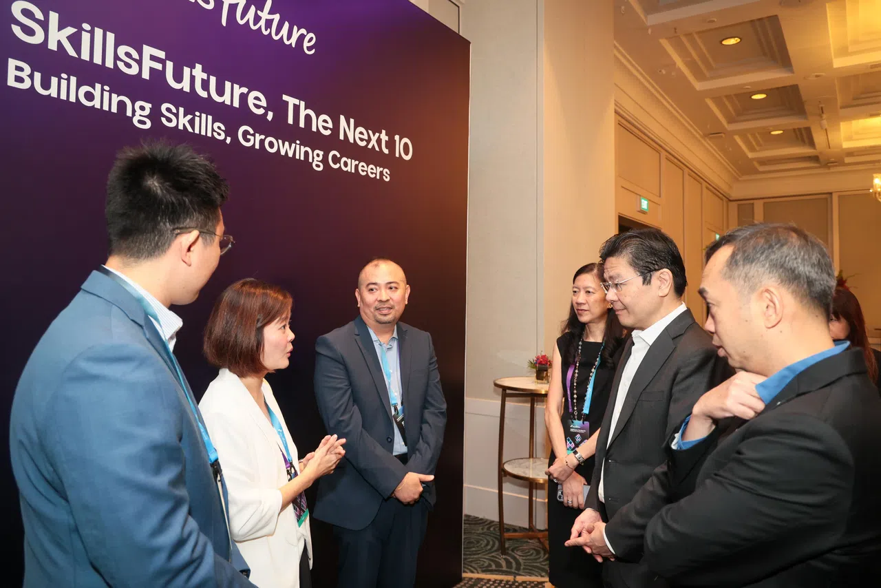 技能创前程10周年庆祝活动的主题，是“技能创前程未来10年——培养技能，成就事业”。总理黄循财（右二）在活动上与企业代表交谈。在场的包括精深技能发展局局长陈谷炎（右一）。（张俊杰摄）