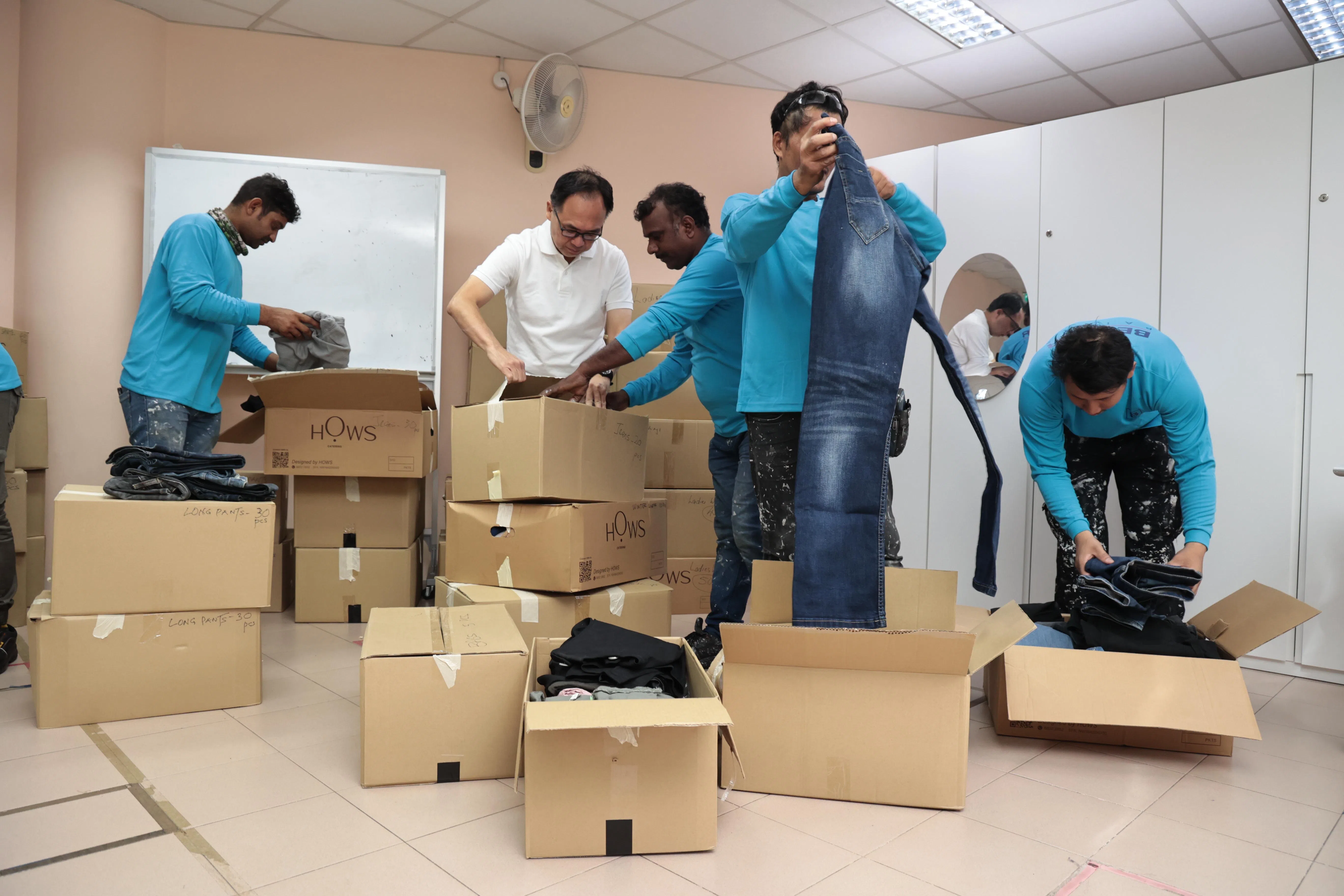 武吉班让区议员连荣华（左二）和客工们一起打开分类装好捐赠衣物的纸箱。（特约陈佩敏摄）