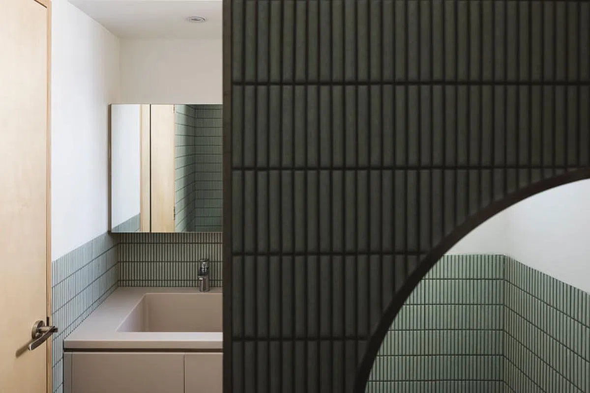 设计师用食指般大小的淡绿长方形Kit Kat瓷砖打造复古风的摩登卫浴间。（Monocot Studio提供照片）