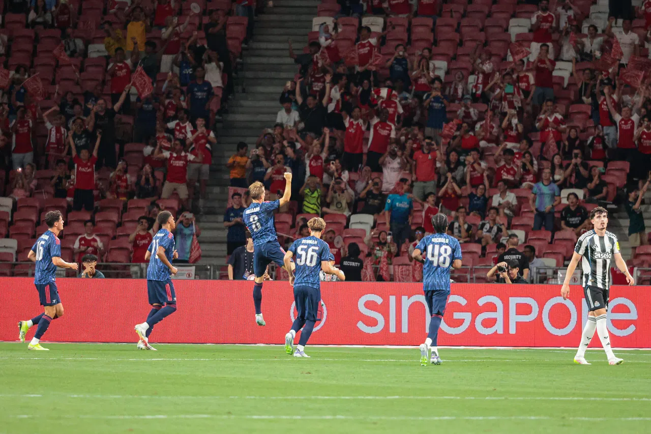 阿申纳队长厄德高（左三）攻入罚球锁定胜局后，高高跳起庆祝。（李冠卫摄）