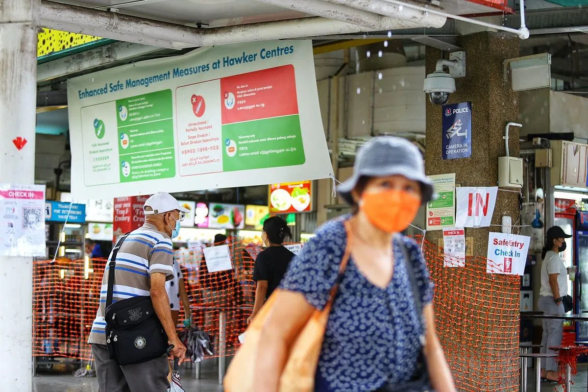 民众随着政策的收紧与放宽，不时调整活动、办公乃至用餐习惯。本地小贩中心张贴海报和布条，提醒公众只有完成疫苗接种才可堂食。大家要共同负起社会责任，接种疫苗，保护自己，也保护身边的人。 （何家俊摄）