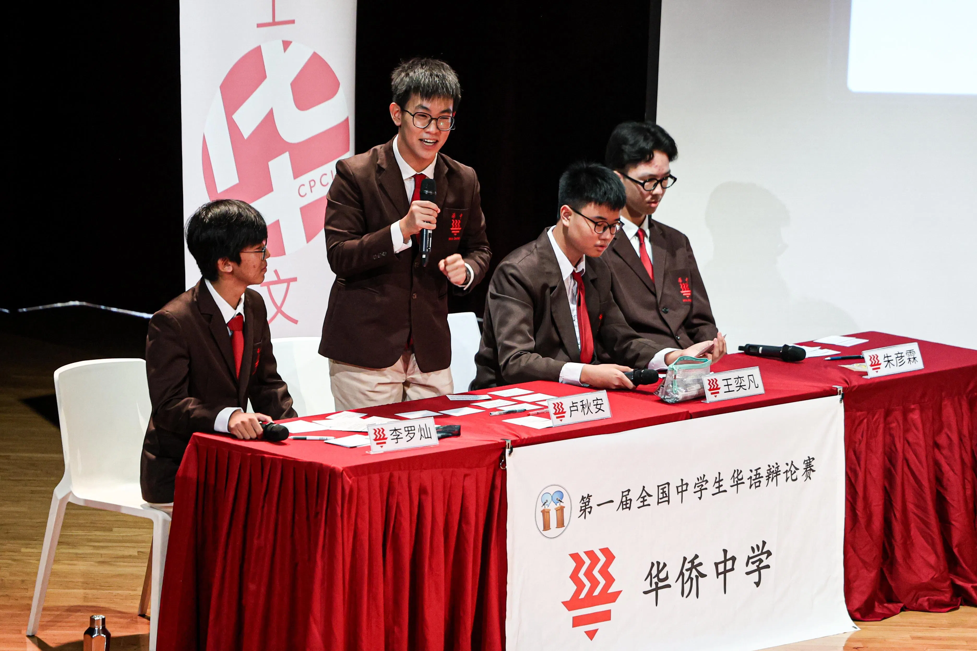 华侨中学辩论队在赛场上神情专注，与对方交锋。（关俊威摄）