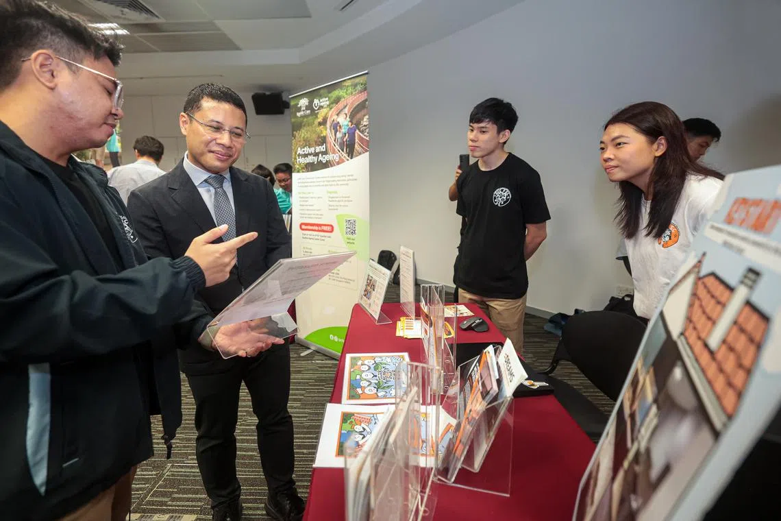 新加坡社科大学的社会工作与发展学院正式成立，教育部长李智陞（左二）在致辞后，参观社会服务机构展位。（李冠卫摄）