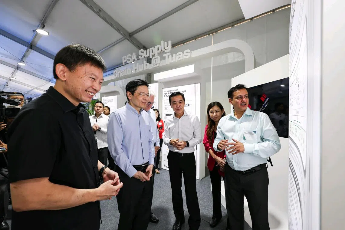 黄循财总理（左二）与交通部长兼财政部第二部长徐芳达（左一）和PSA国际港务集团总裁王金榜（左三）一起参观展示区，进一步了解大士港物流中心的主要科技和特点。（海峡时报）