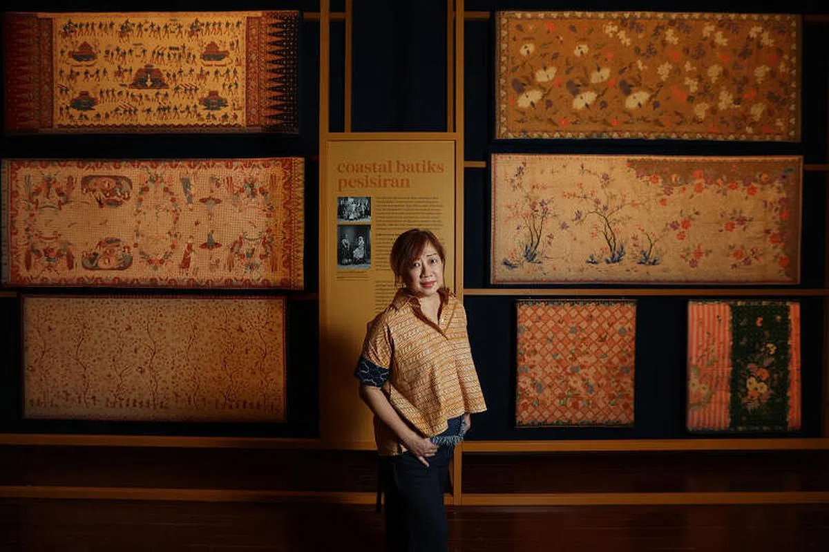 “Batik Kita”策展人李楚琳身后的峇迪展现惊人的多元包容性。左中是爪哇欧亚人的峇迪；左下是1920年代印尼华人作坊的红色峇迪；右边则是绮丽的娘惹峇迪布。（龙国雄摄）