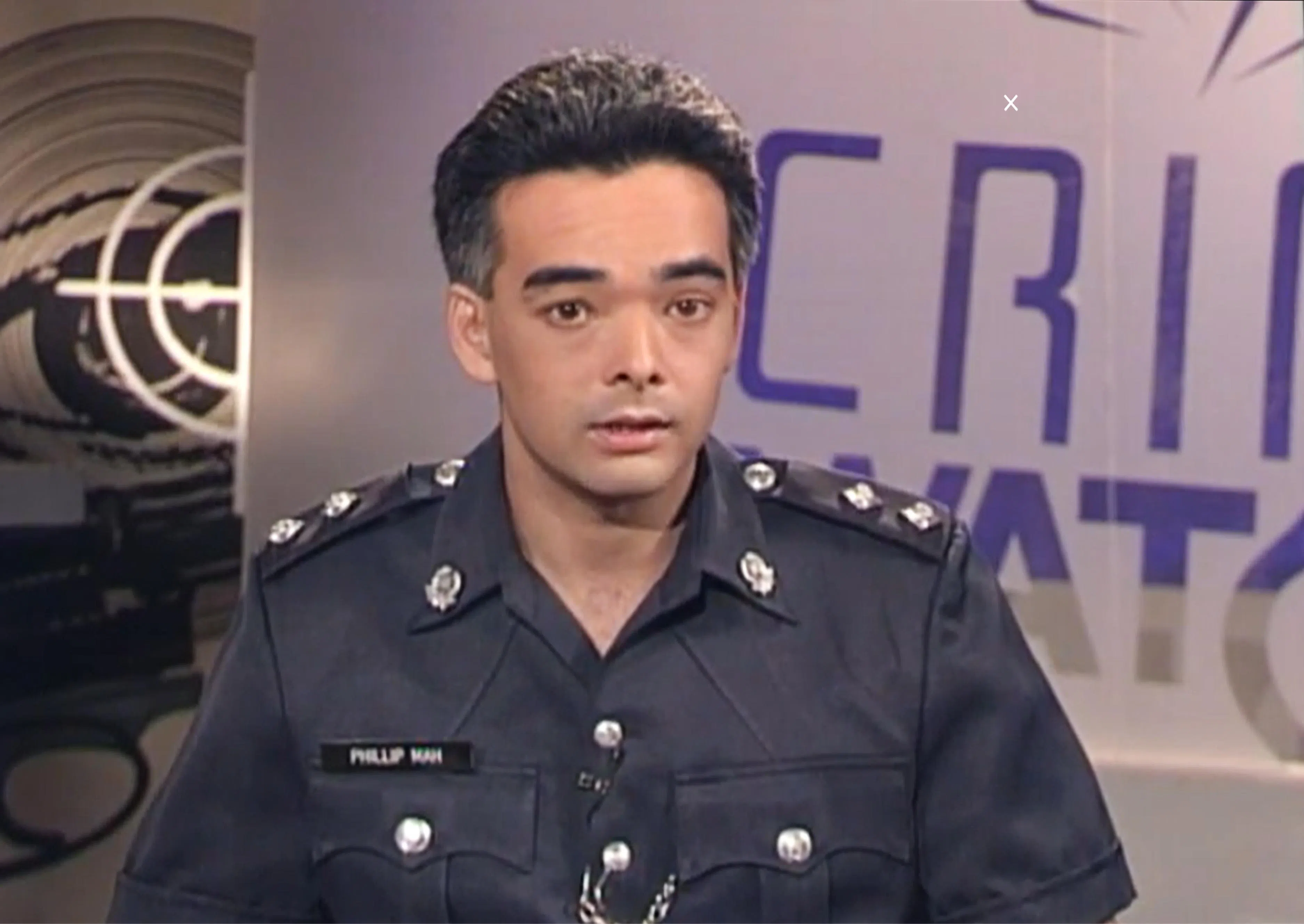 警察公共事务局前助理局长（传媒联络）马文权，从1992年至1995年担任《绳之以法》英语主持人，图为当时的节目画面。马文权现为一家安保公司和估价公司的业务经理。他笑说，至今仍不时会有客户问及节目的事。（节目截图）