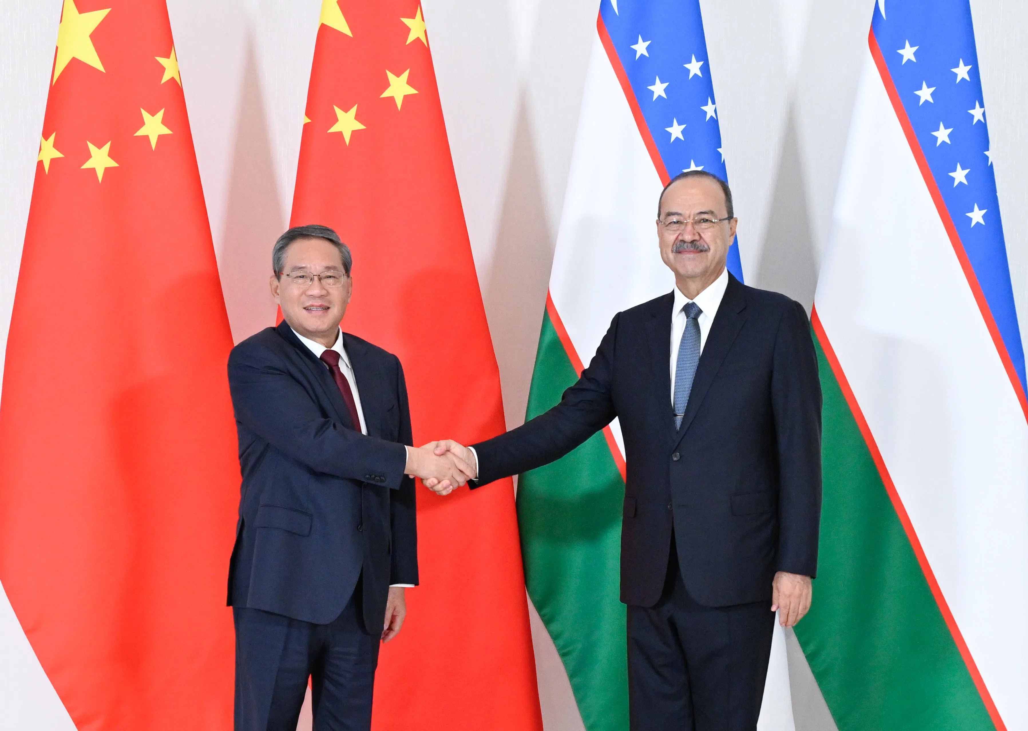 中国国务院总理李强（左）星期六（10月17日）在乌兹别克斯坦首都塔什干与乌总理阿里波夫举行会谈。（新华社）