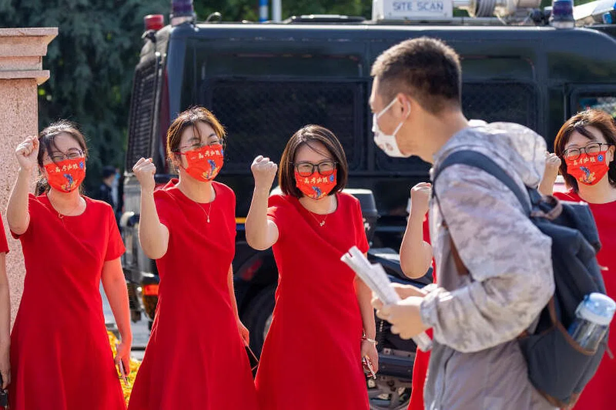 6月7日，在江苏省南京市雨花台中学考点，送考老师为考生加油鼓劲。（新华社）