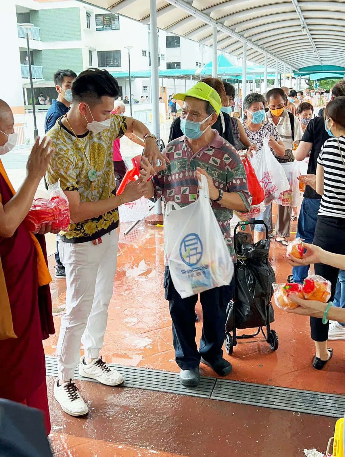  陈俊汉昨天在振瑞路第52座组屋分礼包。（受访者提供） 