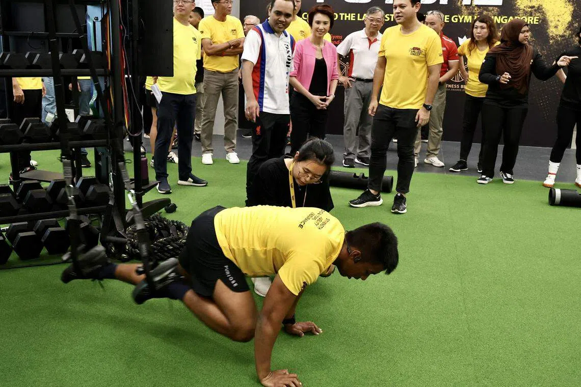 国防部兼人力部高级政务部长扎吉哈（右一，身着黄衣）、蔡厝港集选区基层顾问、贸工部长颜金勇（后排，身着白衣）、蔡厝港集选区议员刘燕玲（身着粉红外套）与周凯年（刘燕玲右）星期天（11日）观摩体能赛的挑战“Elite100”，并参观了新俱乐部的设施。（特约陈来福摄）