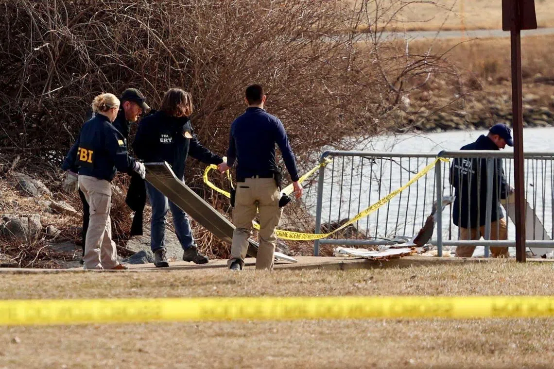 确定撞机事故没有幸存者后，美国当局将搜救工作的重心转为打捞遗体和搜寻飞机残骸。图为紧急救援队星期四把从波托马克河捞上的客机残骸放在一处。（彭博社）