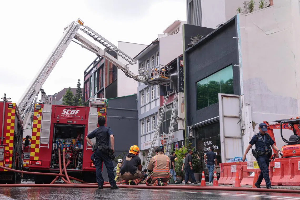消防员到场后立即部署救援梯子和云梯，营救其余被困在窗台上的受困者。（李冠卫摄）