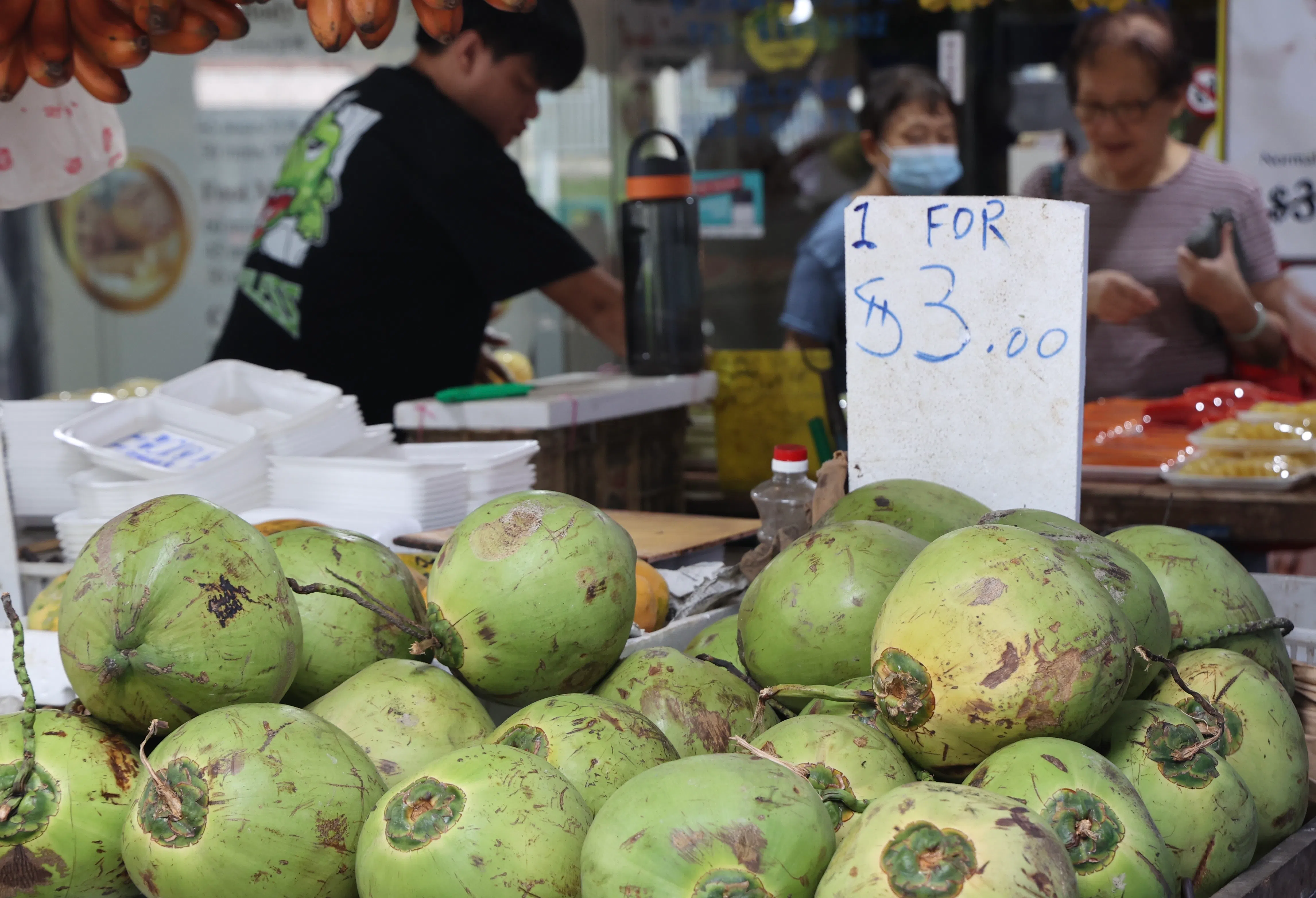 多数受访商贩说，虽然进口椰子的成本上涨了两三成，但他们目前尽可能自己承担上涨的成本。（邬福梁摄）