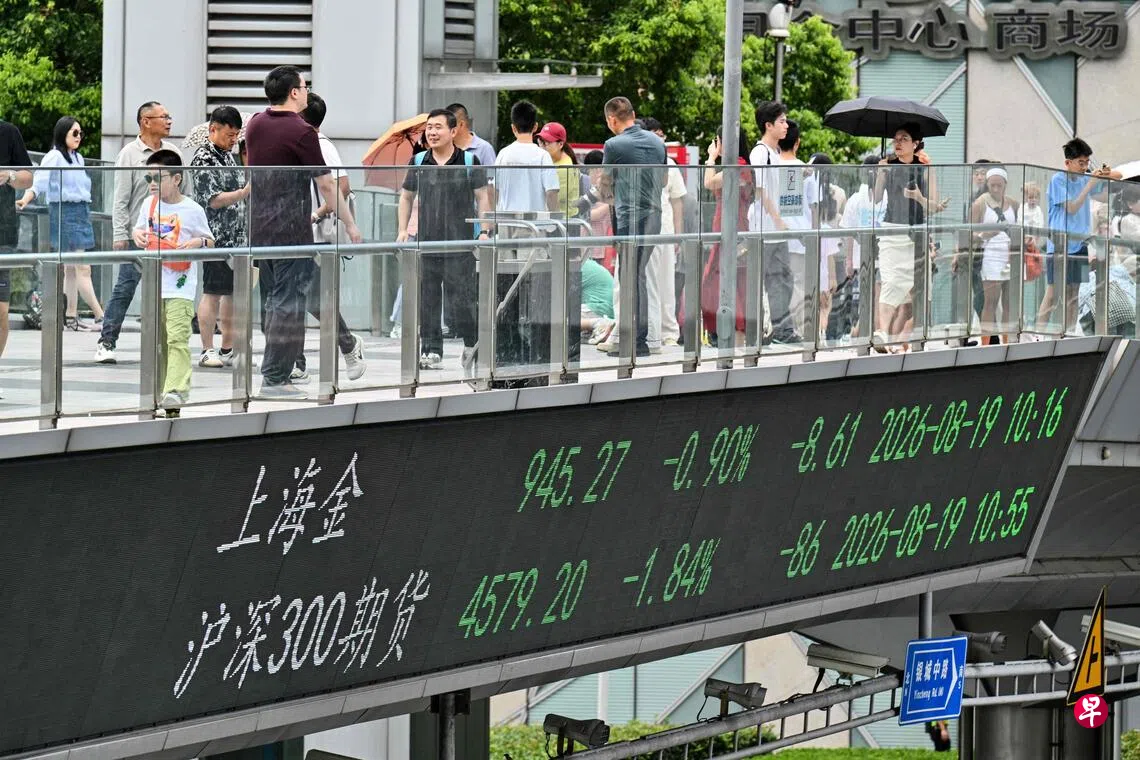8月19日，行人走过上海金融区一座设有金融市场行情显示屏的人行天桥。 （法新社）