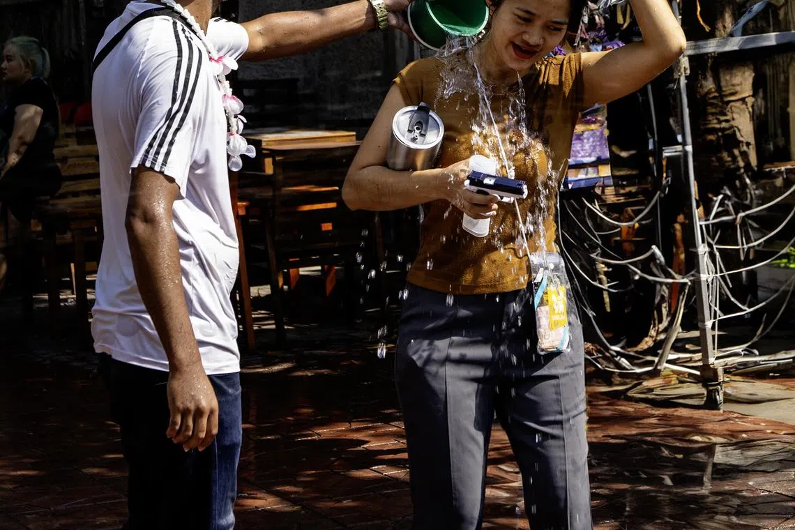 小水桶倒出祝福，也为酷热天气降温。（蔡光发摄）