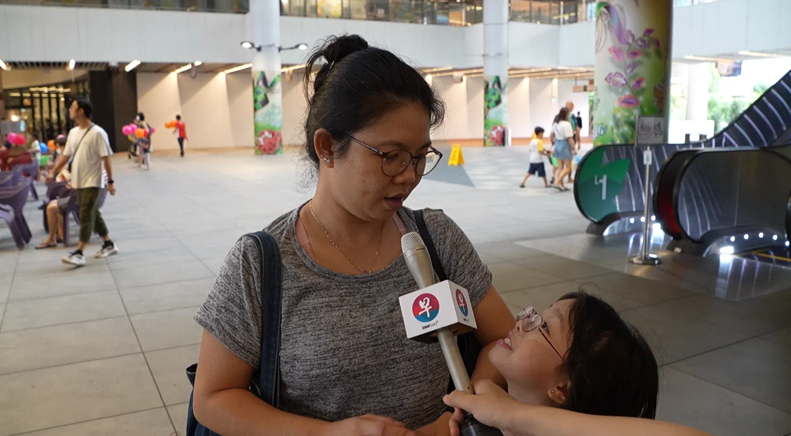 魏丽娟带孩子参观《联合早报》举办的漫画展。