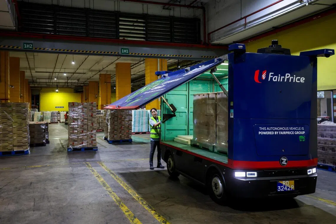 载送一箱箱饮料的自驾电动货车，从百佳仓库启程，运货到平价集团的配送中心。（叶振忠摄）