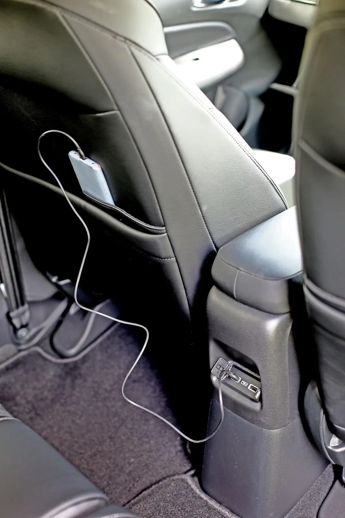 中控扶手后方有两个USB插槽，充电时手机可以放在椅背特制的袋子里。