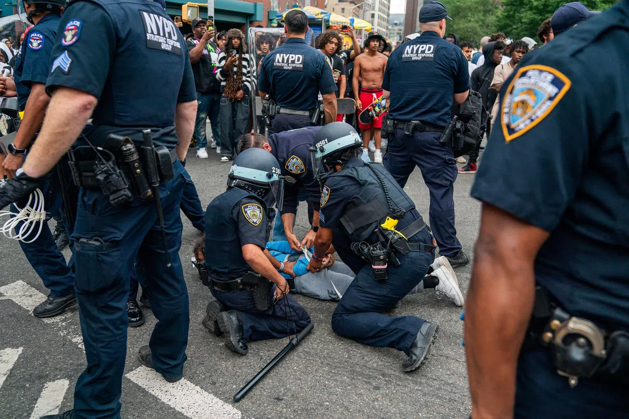 现场有人扔瓶子和椅子，有人破坏施工路障，图为一名闹事者被警察压制。（路透社）