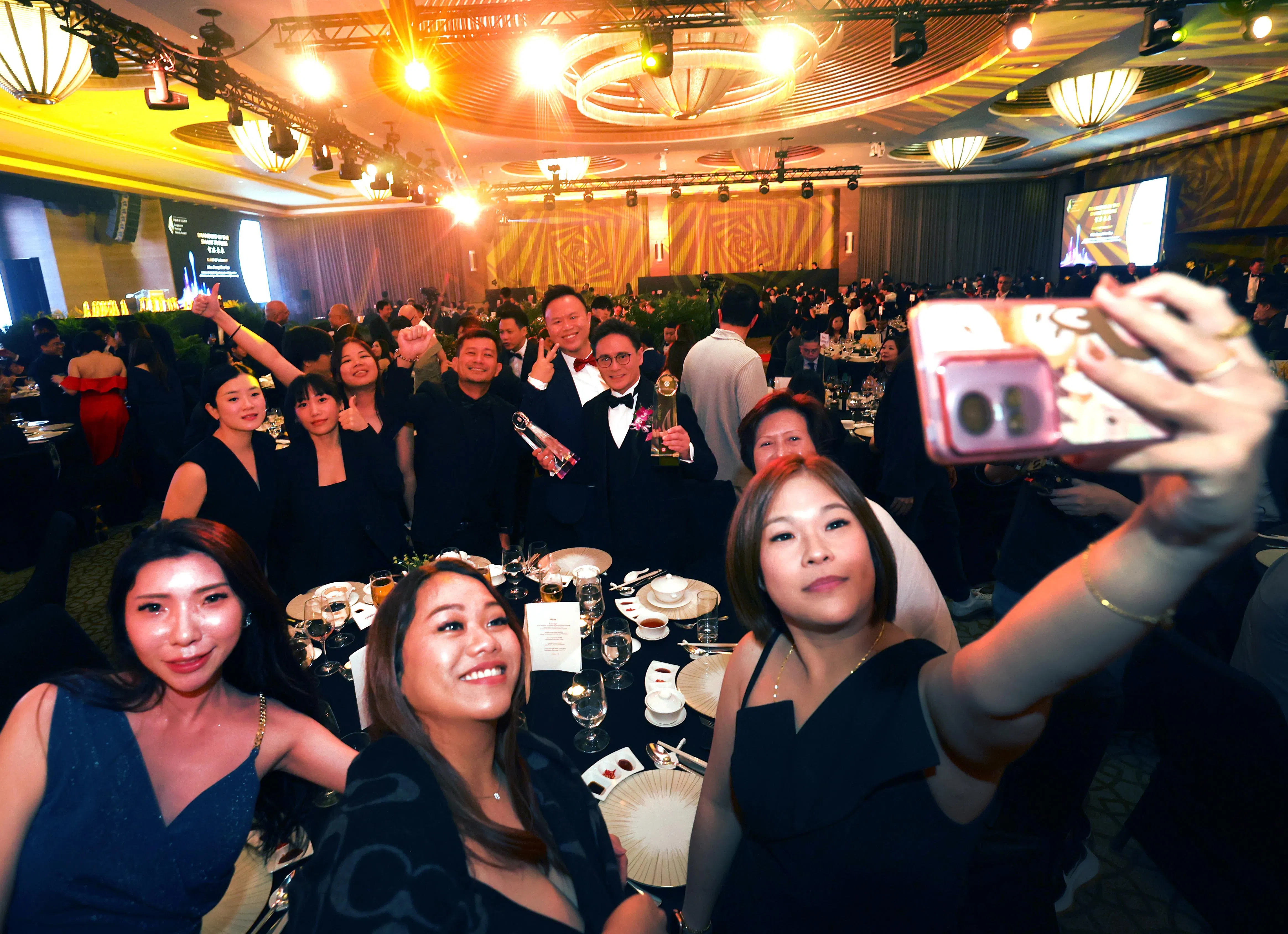 欢庆品牌得奖，少不了拍wefie（群体自拍照）留念。（邝启聪摄）