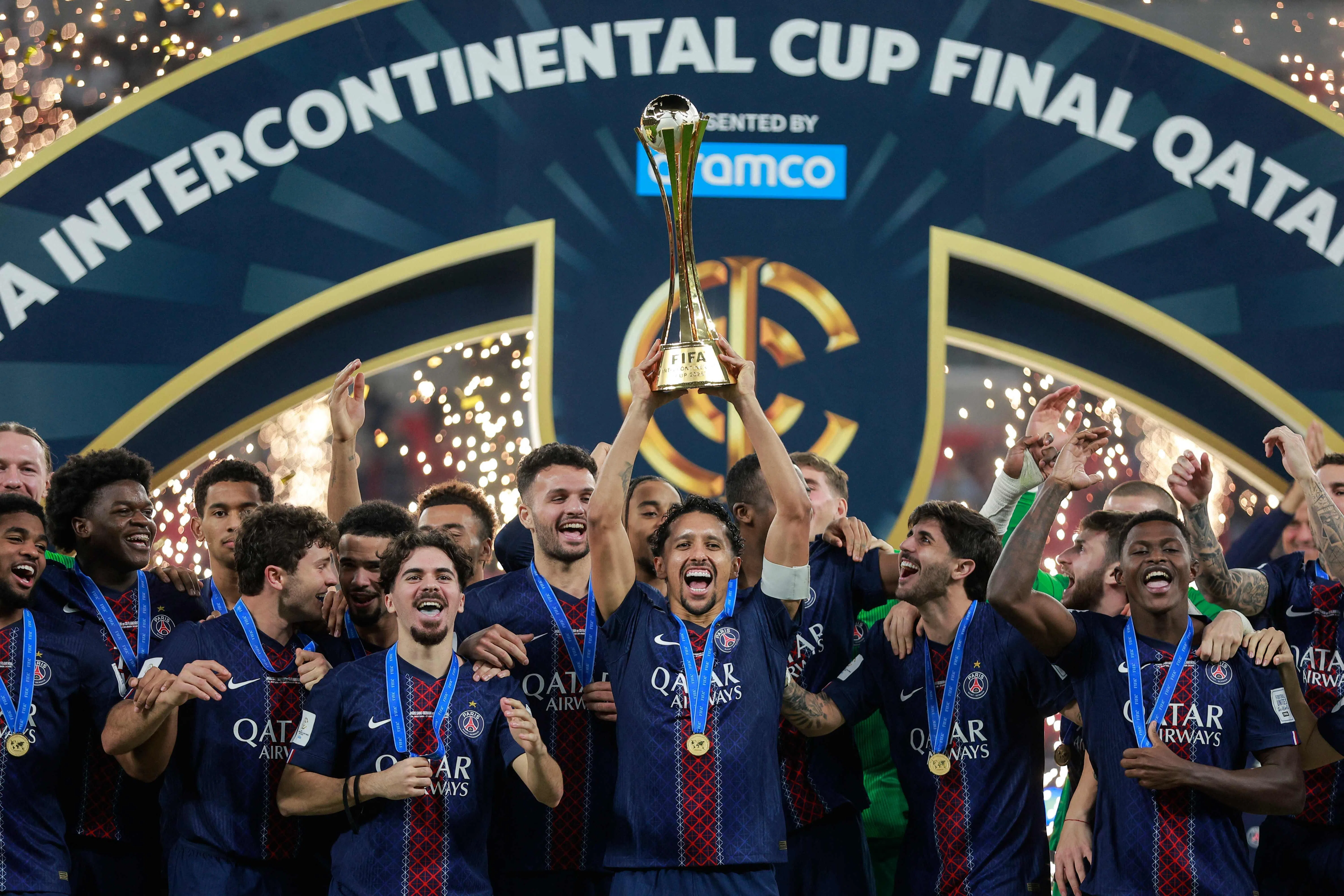 大巴黎本赛季夺得六座冠军奖杯，成为历史第三支“六冠王”球队。图为球队在洲际杯夺冠后，由中卫兼队长马尔基尼奥斯（中）高举奖杯庆祝。（法新社）