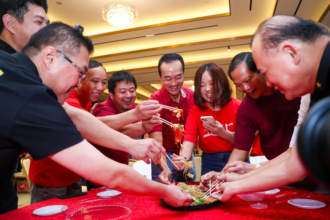 人力部兼永续发展与环境部高级政务部长许宝琨医生（中间）在黄氏总会，同答谢客工晚宴与会者，共捞鱼生。（林明顺摄）