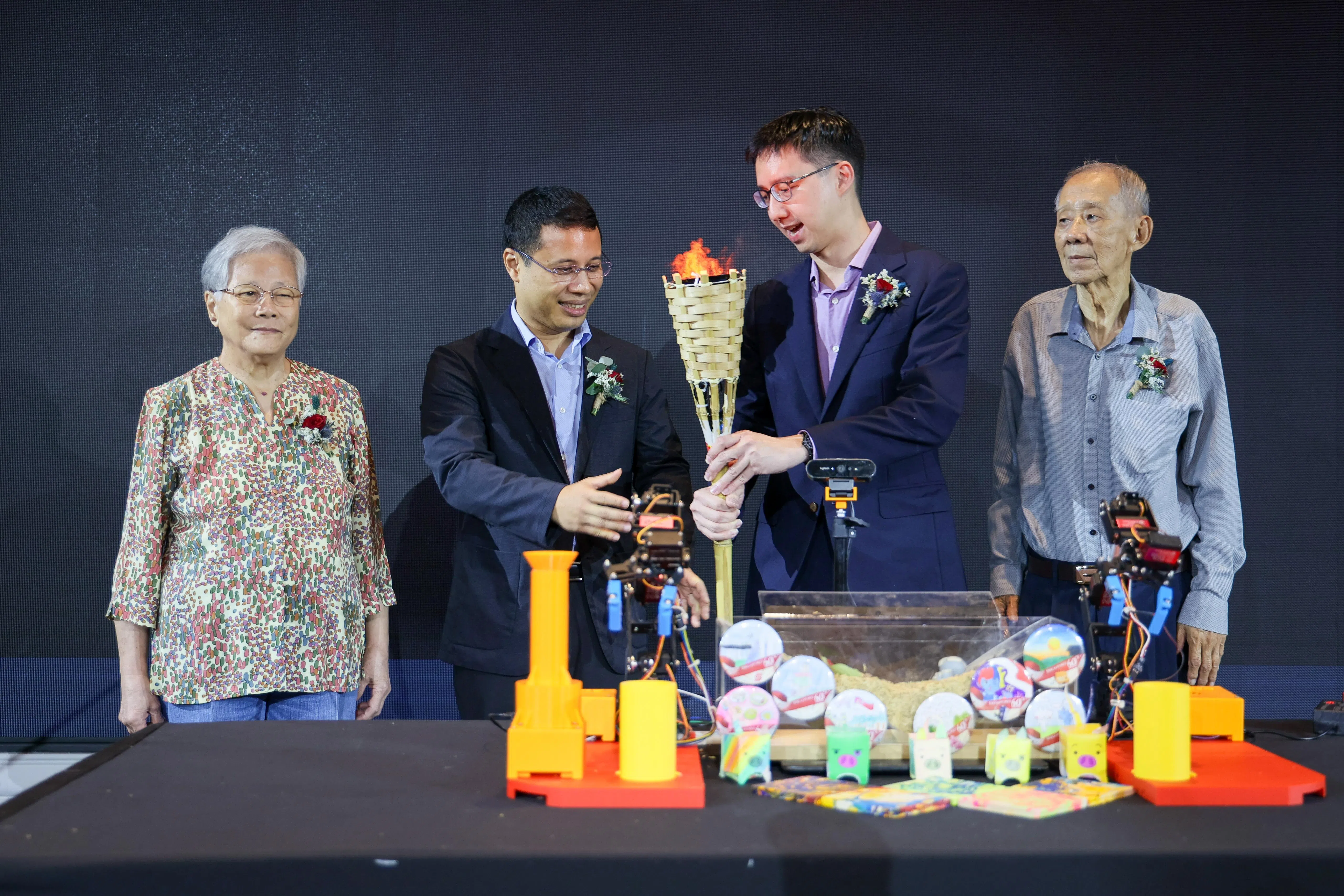 新民中学校长陈顺惠（右二）将火炬交给教育部长李智陞（左二），开启晚宴。两旁分别是校友叶小琳（左一）和黄安嵘（右一）。（张俊杰摄）