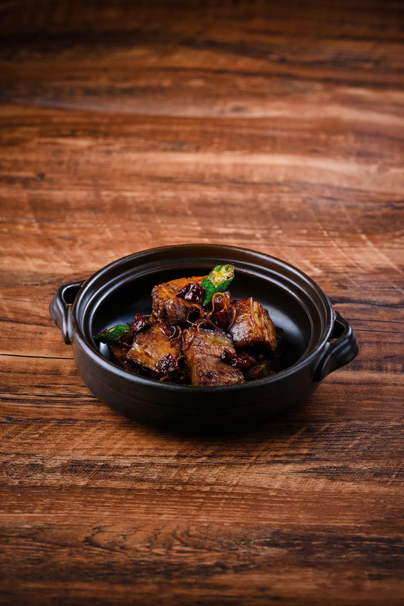 干辣的招牌巴生肉骨茶以五花肉为主角，烹煮时加入浓缩汤汁，搭配辣椒、秋葵等配料，焦香辛辣。（餐馆提供）