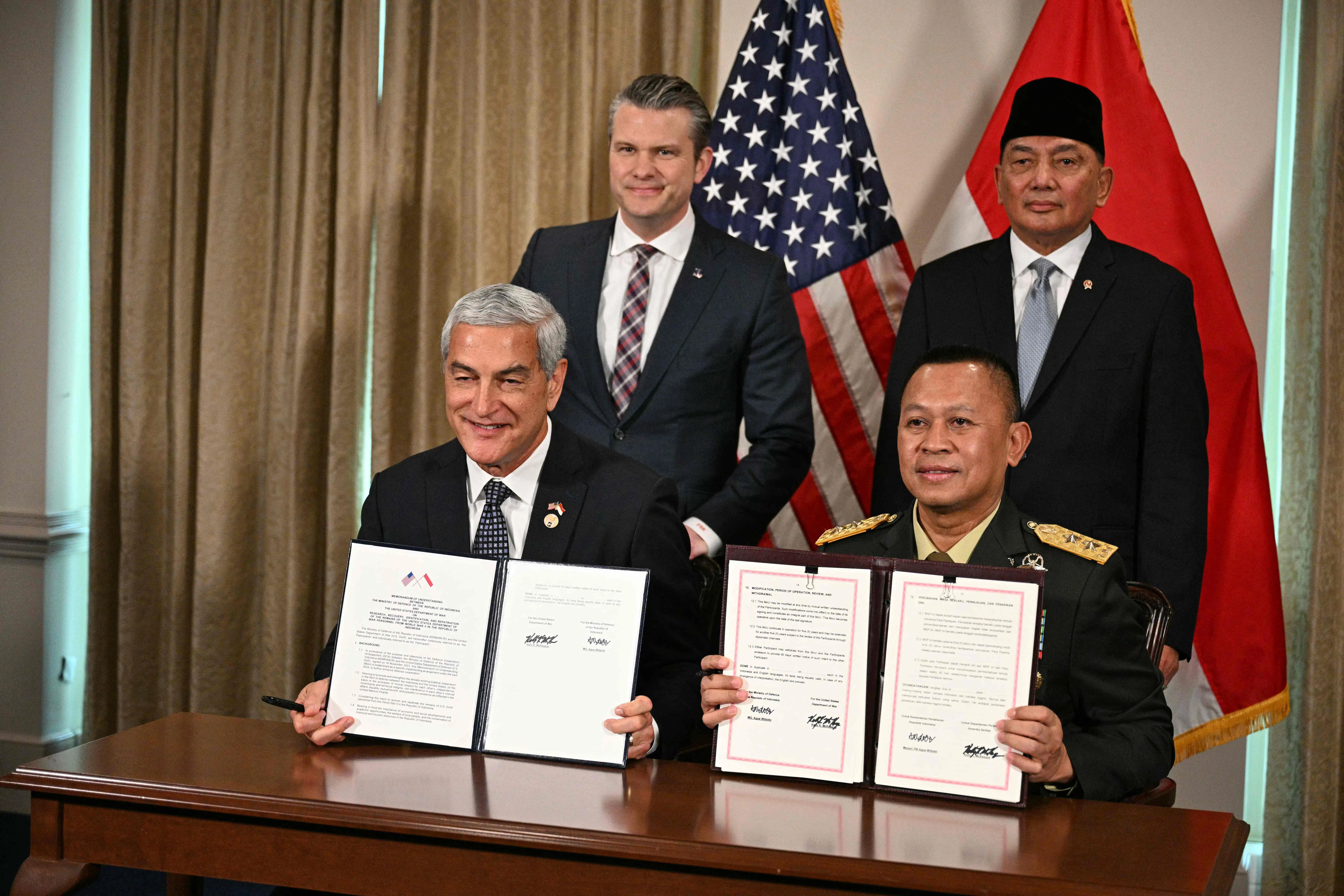 美国战争部长赫格塞斯（后排左）与到访华盛顿的印尼防长夏弗里（后排右）一同见证双方代表签署关于在印尼搜寻、打捞、鉴定和移送二战期间美国军人遗骸的谅解备忘录。（法新社）
