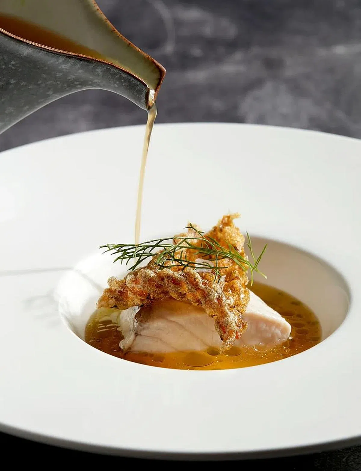 澳洲肺鱼同时以蒸和炸的方式呈现，有泰式青柠蒸鱼风味的蒜柠汤汁，清新开胃。（餐馆提供照片）