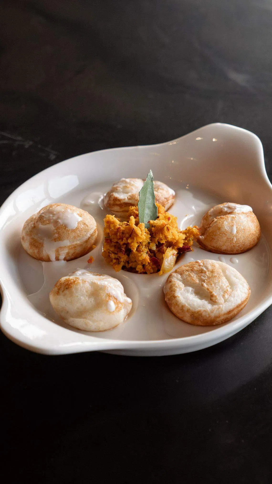 以椰浆和米制成的传统饼球小吃“Colonial Dutch Oven Sweet Gundappam”。（餐馆提供）