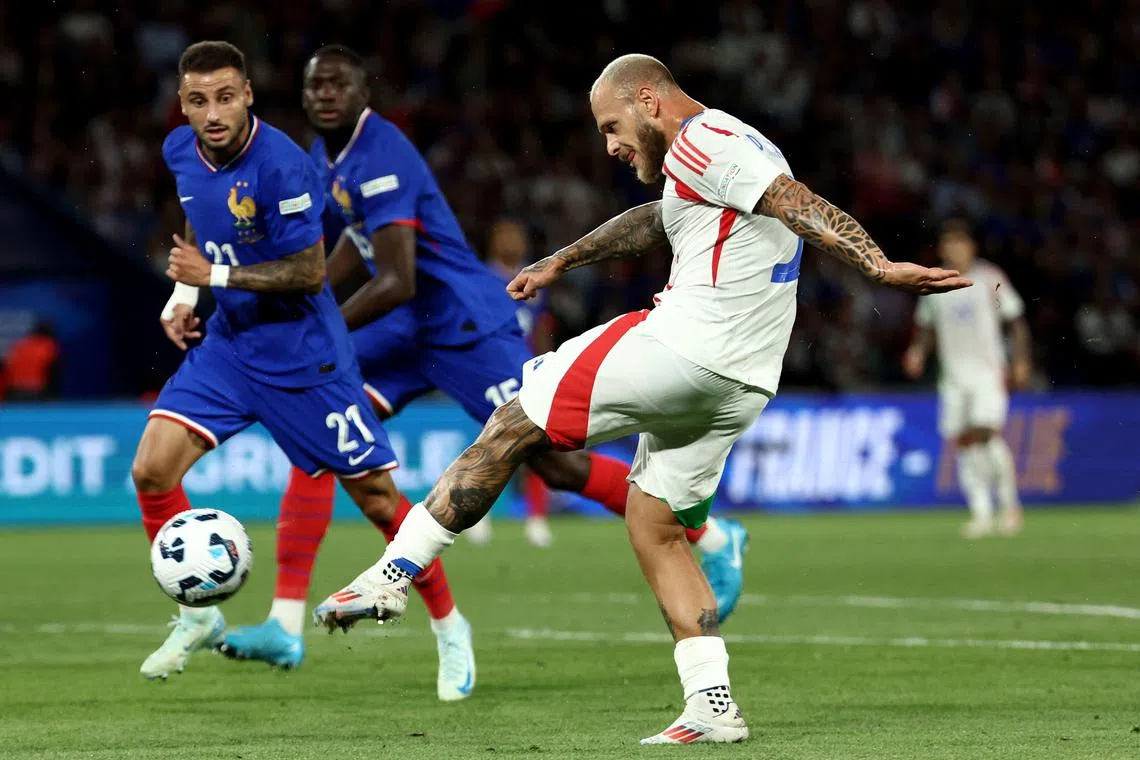 意大利左翼卫迪马尔科（白衣）在禁区凌空抽射得分，为球队扳平比分。（法新社）