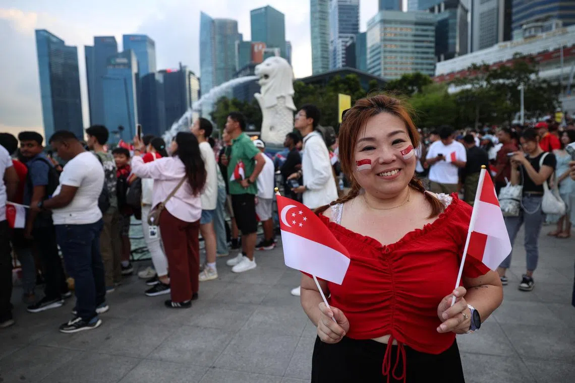 公务员刘冠町一早就到鱼尾狮公园占位，亲身参与国庆盛典。（关俊威摄）