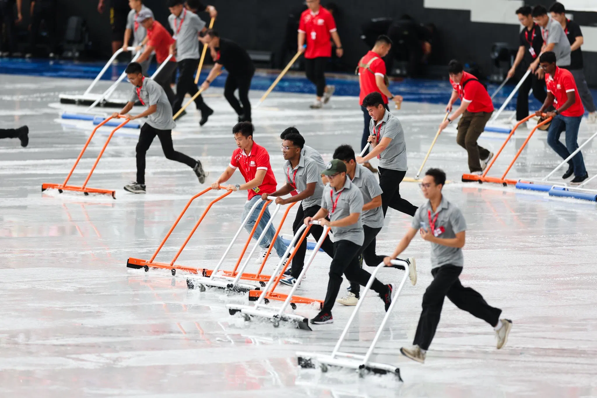 突如其来的一阵雨将舞台和座位都淋湿了。雨停后，在场工作人员立即清理舞台积水，为国庆庆典做好准备。（蔡家增摄）