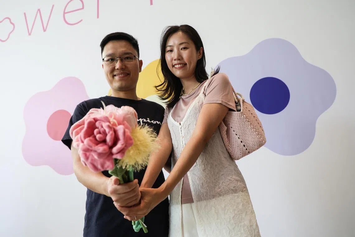 金融分析师卓伟聪（左）是球迷，为陪妻子叶婧雯选购绒花，他放弃观看6月14日清晨巴西队对阵摩洛哥的世界杯球赛。（关俊威摄）