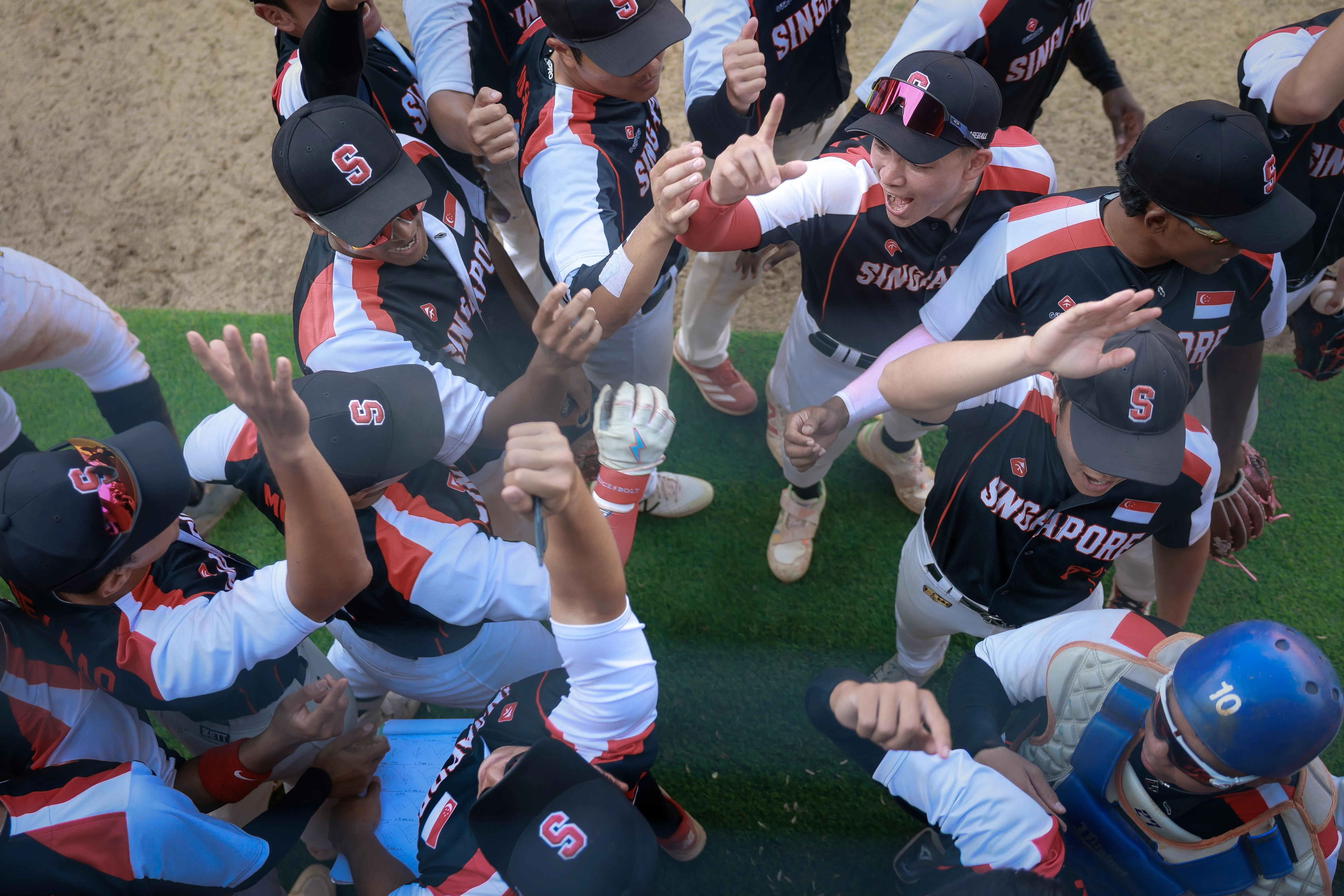 我国健儿相互加油打气，希望在接下来对阵马来西亚和印尼的比赛中拿出更好表现。（海峡时报）