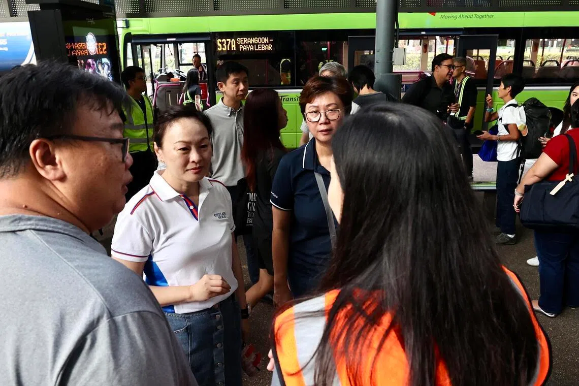 马林百列—布莱德岭集选区议员、负责芽笼士乃分区事务的彭丽燕（左二）星期一上午约8时出现在巴耶利峇接驳巴士站，观察接驳巴士乘客的排队情况。（邬福梁摄）