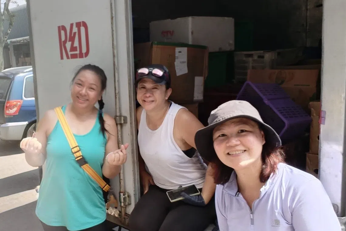 The Red Collective co-founder Winnie Cheong (center) works with volunteers to distribute food in the Eunos neighbourhood.