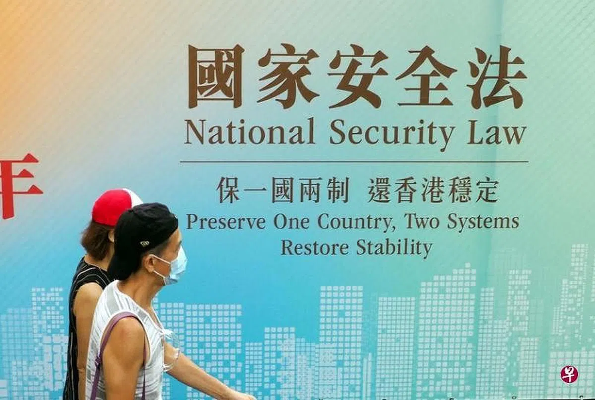 去年6月30日《香港国安法》生效。图为香港市民经过街头《香港国安法》的宣传标语。（中通社） 