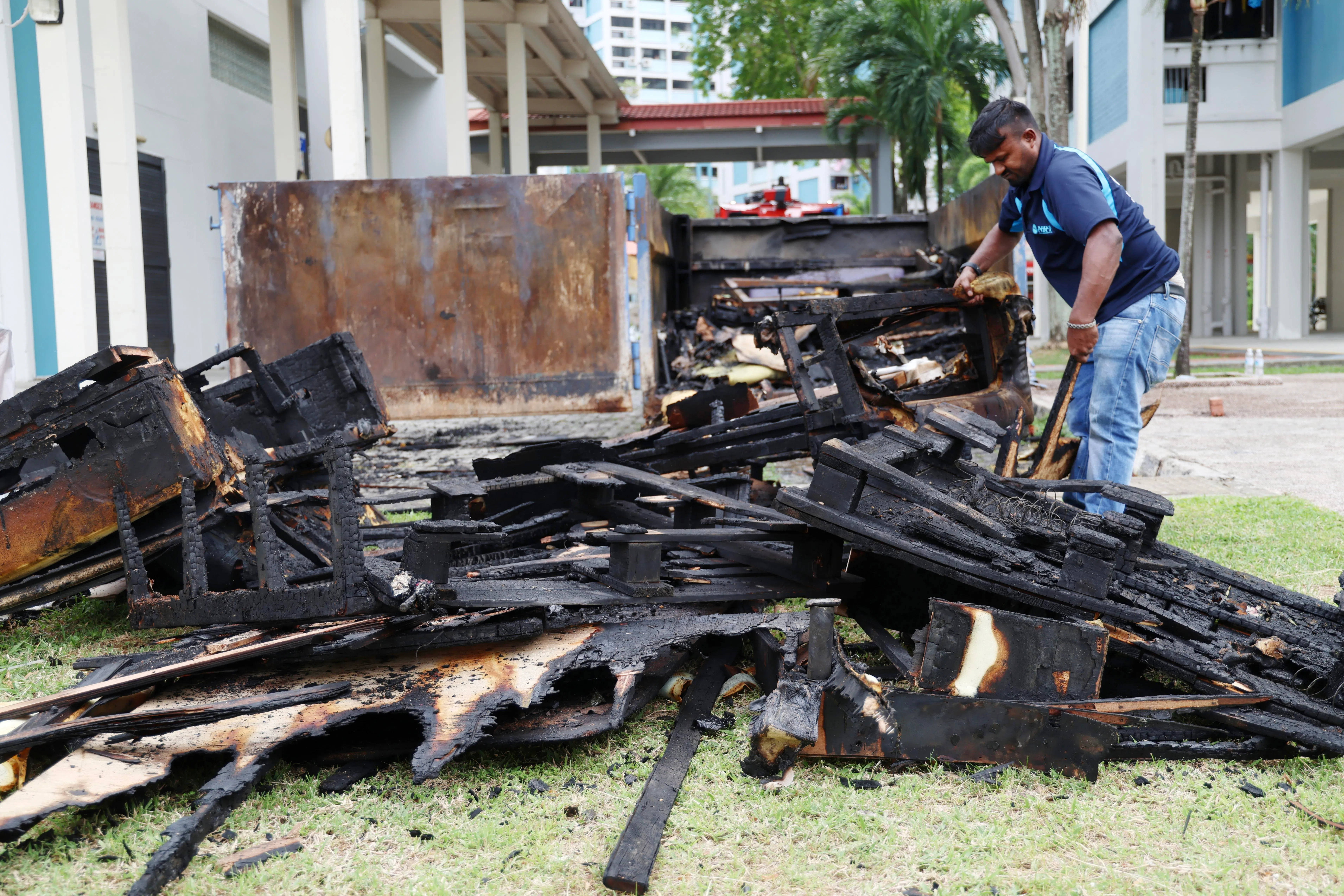 清洁工苏蒙在火扑灭后不久便展开清理工作，把烧得焦黑的家具拖出。（郑一鸣摄）