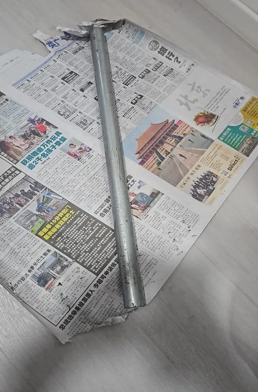 为了掩盖铁棍，被告用报纸将铁棍包起。（取自法庭文件）