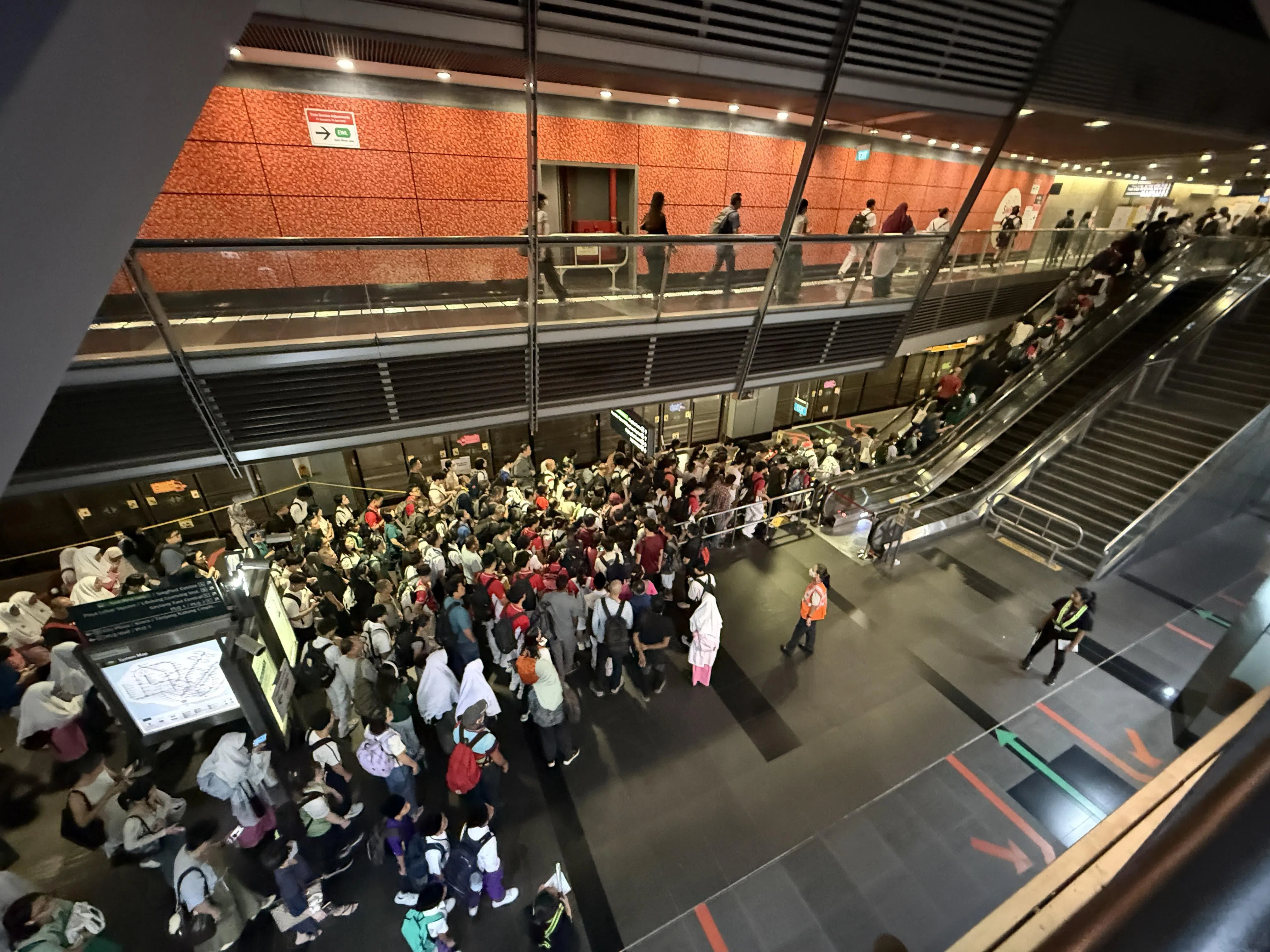 巴耶利峇地铁转换站的乘客人流不断，但整体尚算有序。现场有工作人员在旁协助和指引方向。（邬福梁摄）