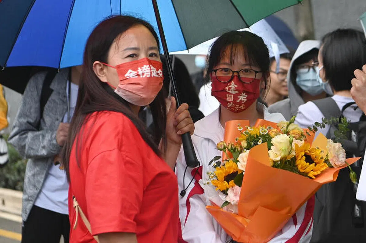 6月8日，家长戴“金榜题名”口罩在昆明市北清实验学校考点外迎接考生。（中新社）