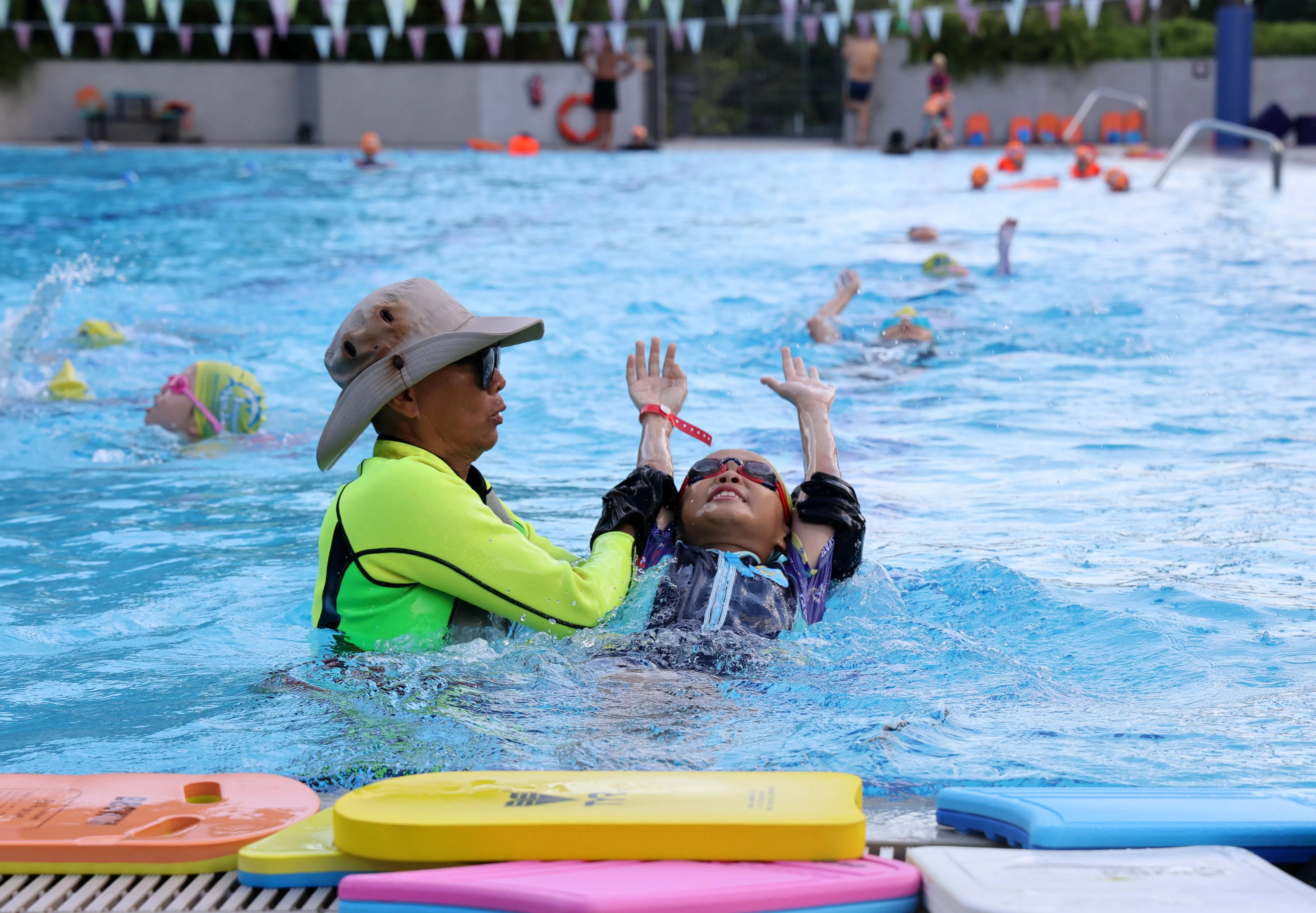 数据显示，使用积分次数最多的三个项目，分别为购买健身房通行证、游泳池通行证，以及预订运动设施。图为一名游泳教练在武吉坎贝拉综合体育及社区中心泳池，教导年轻学员游泳。（萧紫薇摄）