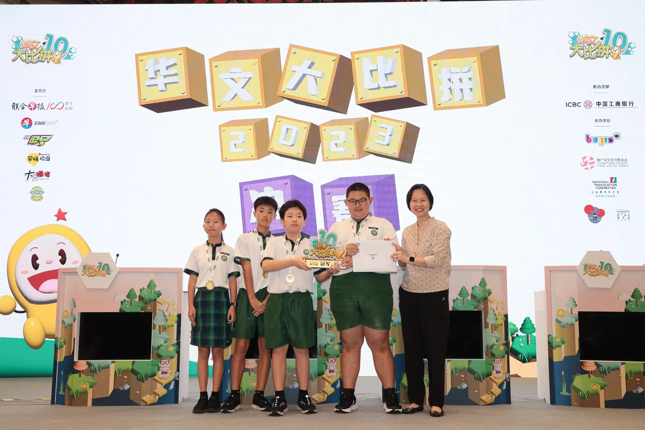 丹绒加东小学在20道抢答题中成功答对其中七道，成功领跑并最终获得小学组冠军。图为教育部兼人力部政务部长颜晓芳（右）为获奖学生颁奖。（李冠卫摄）
